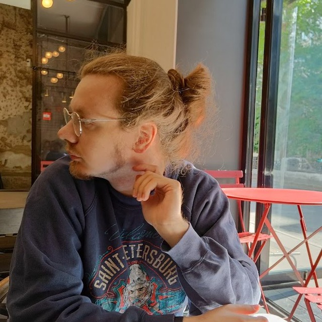 a picure of me (the guy with light long hair looking to the left, in glasses, sitting in a cafe in a blue sweatshot with saint-petersburg words on it.)